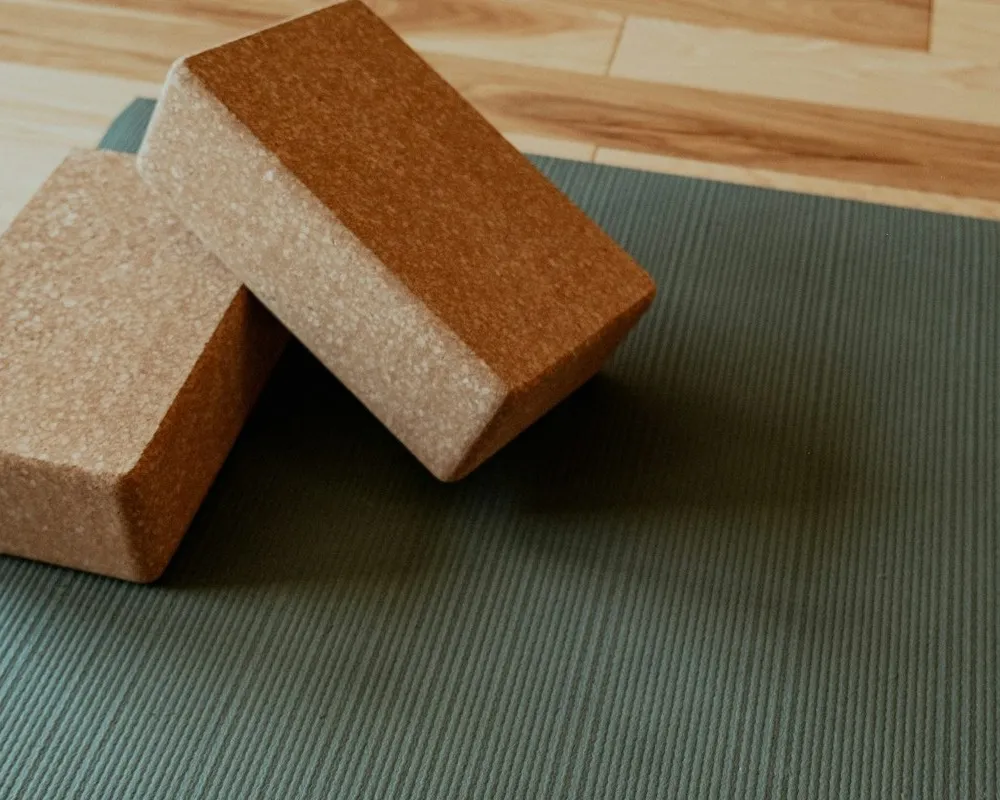 Two cork blocks resting on a green yoga mat