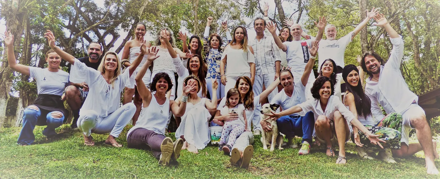 A joyful group dressed in white waving on the grass