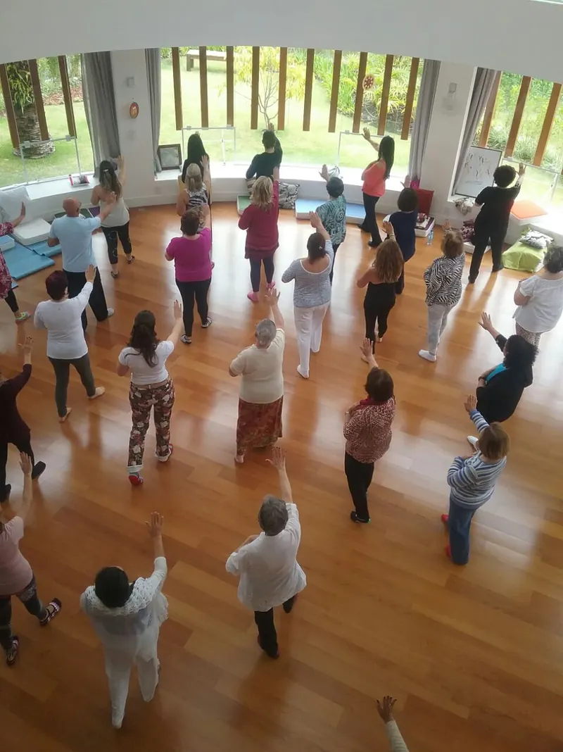 A group practising movement in a sunlit studio, seen from above