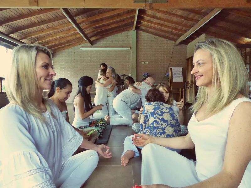 Two women smiling at each other during a partner exercise on a retreat