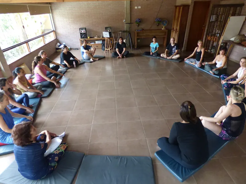 A sharing circle on mats in a bright brick studio